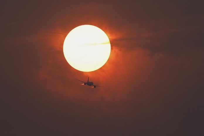 Ουάσιγκτον, DC – 7 Ιουνίου: Μια εμπορική αεροπορική εταιρεία πετάει μπροστά από τον ήλιο που καλύπτεται από την ομίχλη που προέρχεται από τον καπνό των καναδικών πυρκαγιών (Φωτογραφία: Anna Moneymaker / Getty Images via AFP)