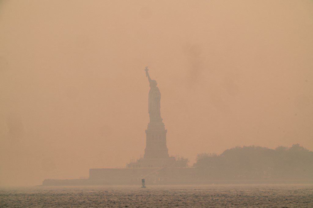 Νέα Υόρκη – 07 Ιουνίου: Η πορτοκαλή ομίχλη από τις πυρκαγιές στον Καναδά περιβάλλει το Άγαλμα της Ελευθερίας στο Upper Bay (Φωτογραφία: David Dee Delgado / Getty Images via AFP)