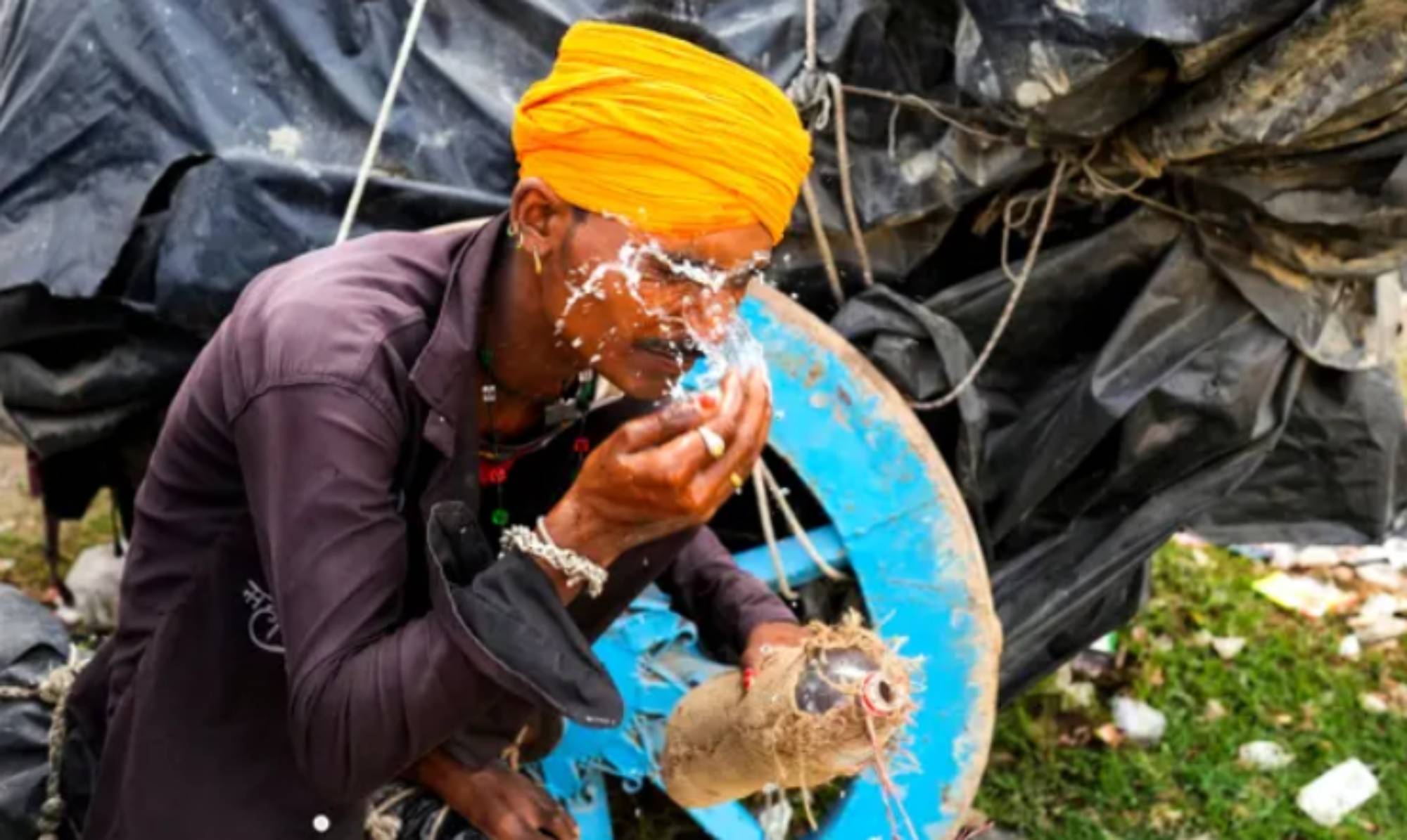 Ένας άνδρας ρίχνει νερό στο πρόσωπό του για να δροσιστεί στο Ουτάρ Πραντές. (Photo: Rajesh Kumar Singh/AP)