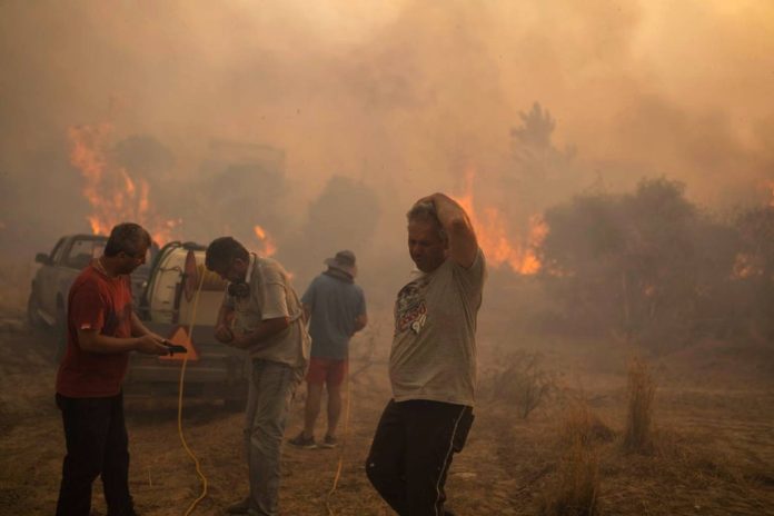 Ντόπιοι προσπαθούν να σβήσουν πυρκαγιά στο χωριό Γεννάδι της Ρόδου την Τρίτη 25 Ιουλίου (Photo: Πέτρος Γιαννακούρης/Associated Press)